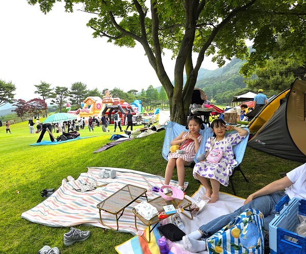 서원밸리 그린콘서트가 개최되는 페어웨이 그늘에서 어린이 동반 가족이 편안하게 쉬고 있는 모습 