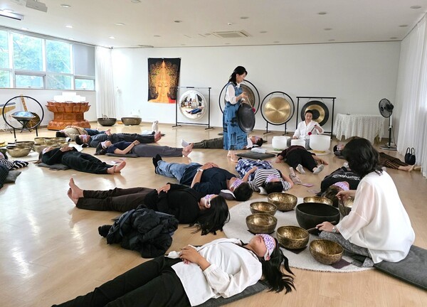 제2회 부탄 문화의 날 부산 행사가 개최된 홍법사에서 운영하고 있는 (사)싱잉볼치유의소리에서 부탄 공연단이 치유를 받고 있는 모습 [사진=이상인 편집위원]