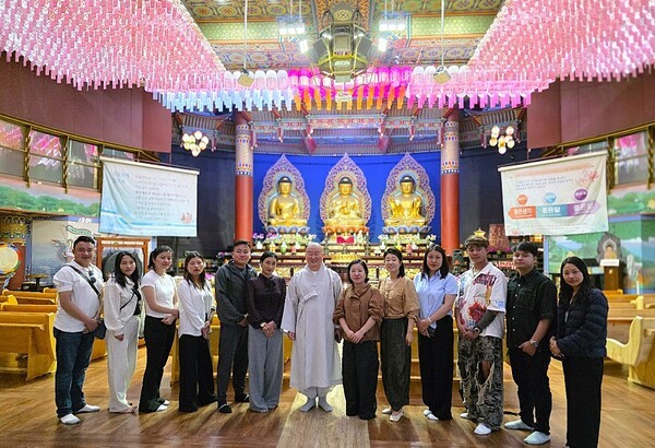 제2회 부탄 문화의 날 부산 행사가 개최된 홍법사 법당에서 사복 차림의 부탄 공연단이 심산 주지스님과 함께 기념사진을 촬영했다 [사진=이상인 편집위원]